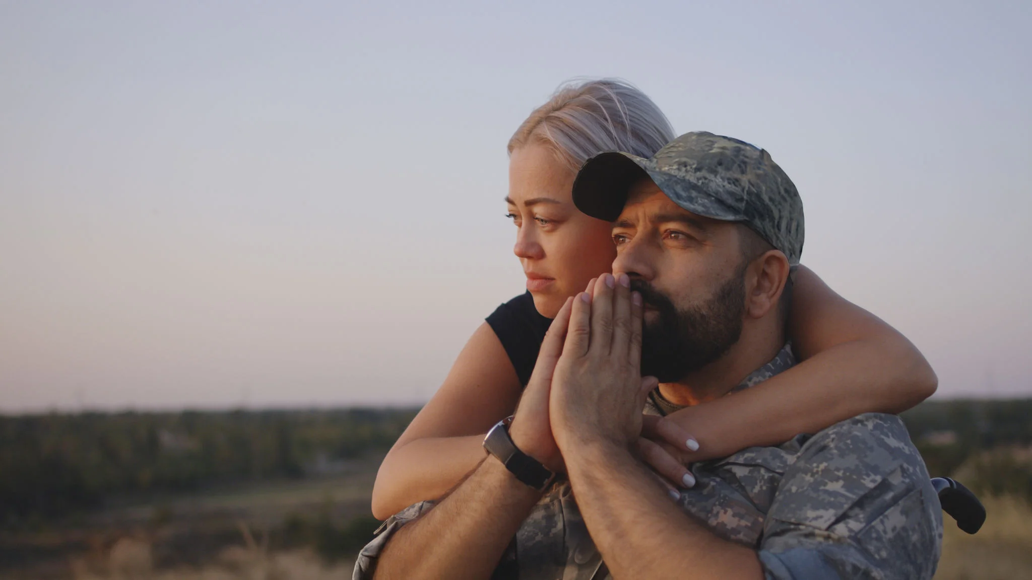1177656605 Medium close-up of wife hugging wheelchaired soldier husband