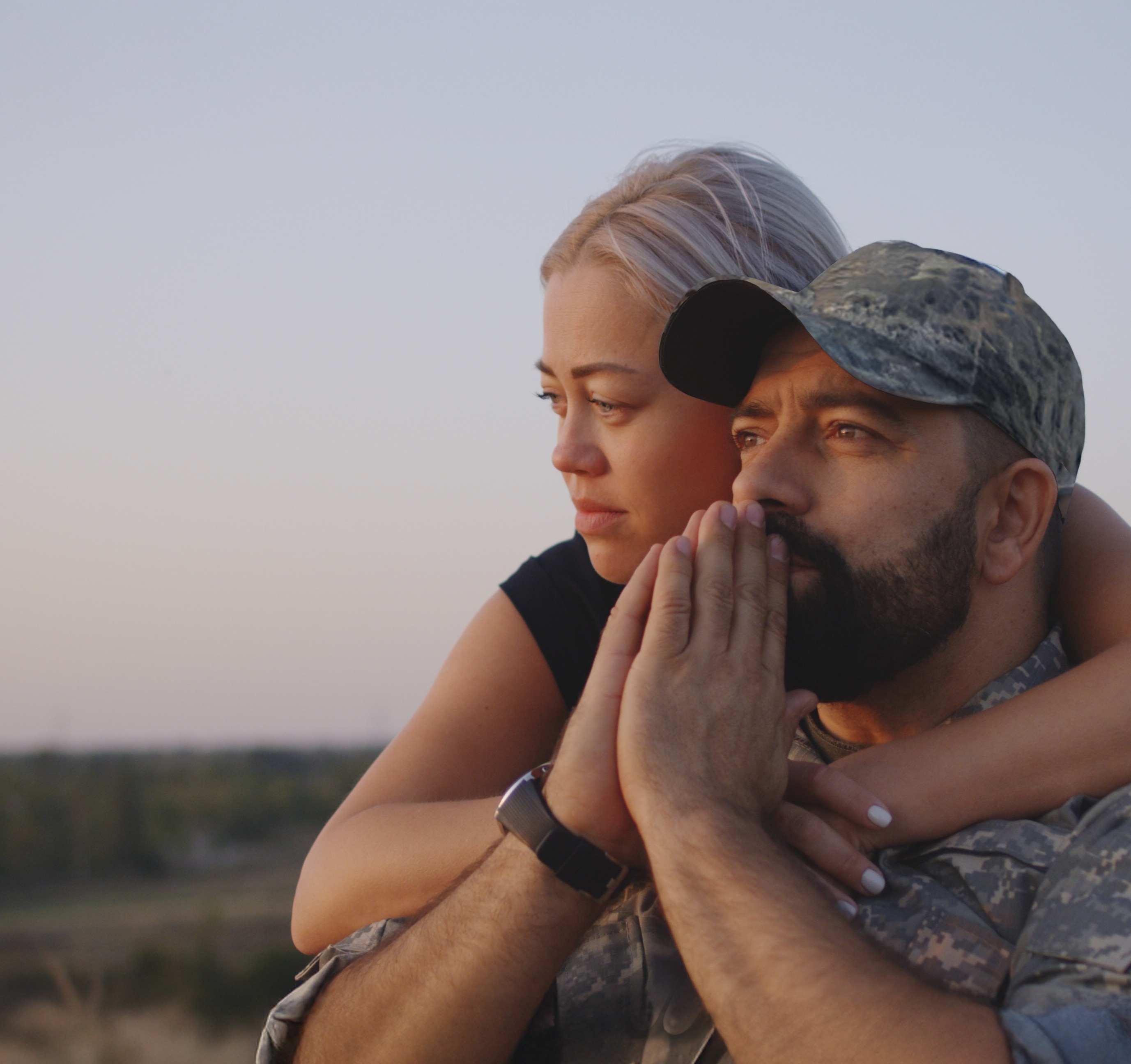 Medium close-up of wife hugging wheelchaired soldier husband